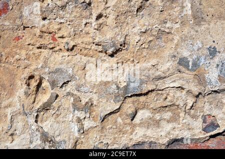 Empty old brick wall texture. Shabby facade of a building with damaged plaster. Stock Photo
