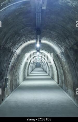 Old concrete tunnel with fluorescent lights. Stock Photo