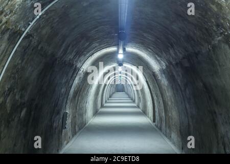 Old concrete tunnel with fluorescent lights. Stock Photo
