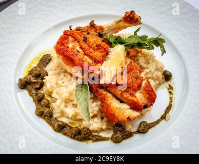 A dish to look forward to: Petto di Faraona. A stunning lemony guinea fowl with caper basil salsa and lemon risotto.. Gourmet Dish in Hotel Mühle in Binzen, Germany Stock Photo