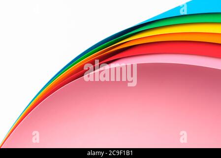 Paper pages stack in rainbow colors with curved corners isolated on white background. Creative layout of blank paper notes with a folded corner. Stock Photo