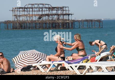 Brighton UK 31st July 2020 - Time to get plenty of sun screen on as sunseekers flock to  Brighton Beach today on what is expected to be the hottest day of the year so far  with temperatures  forecast to reach well over 30 degrees in the south east . The weather is then set to cool down over the weekend: Credit Simon Dack / Alamy Live News Stock Photo