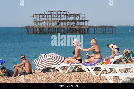 Brighton UK 31st July 2020 - Time to get plenty of sun screen on as sunseekers flock to  Brighton Beach today on what is expected to be the hottest day of the year so far  with temperatures  forecast to reach well over 30 degrees in the south east . The weather is then set to cool down over the weekend: Credit Simon Dack / Alamy Live News Stock Photo