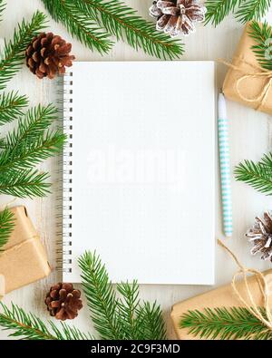 White open notepad, bullet journal for wish list and Christmas decoration on white wooden background, flat lay, copy space. Hand crafted, plastic free Stock Photo