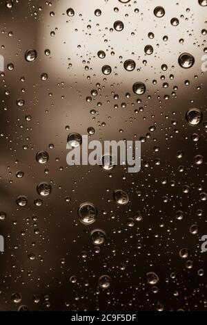 Drops of water on a window pane, raindrops on a window, abstract, black and white photo Stock Photo