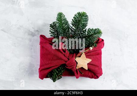 Zero waste, eco friendly concept. Furoshiki gifts present wrapping with linen fabric and fir tree branch. Top view, flat lay Stock Photo