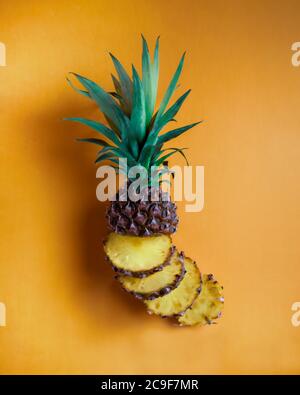 Pineapple slices arranged on orange background Stock Photo