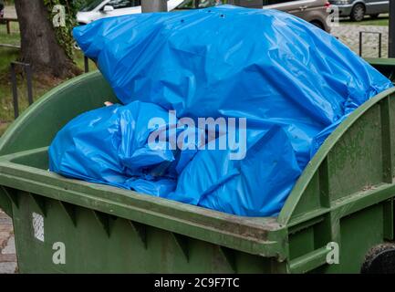 blue garbage bin green container Stock Photo