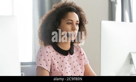 African American female call center operator in headset using computer Stock Photo