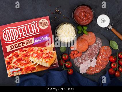 LONDON, UK - NOVEMBER 20, 2019: Box of Goodfella's Deep Pan BakedMeat Feast pizza with salami, cheese and tomatoes on black background. Stock Photo