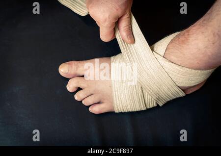 Middle-aged Caucasian man produces an independent bandage of