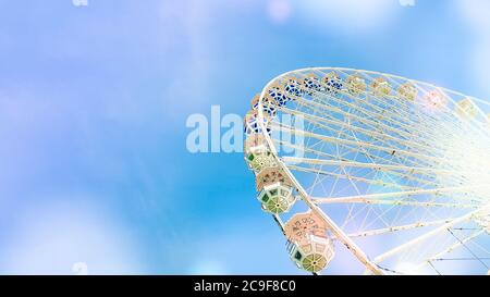 ferris wheel on the background of blue sky with round colorful bright circles Stock Photo