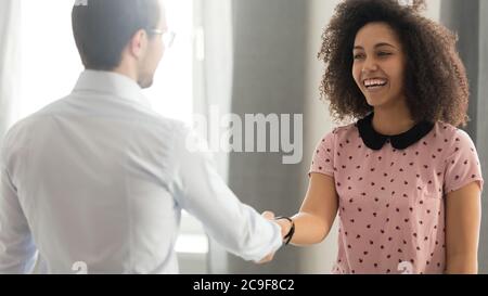 Executive, team leader shaking hand of successful diverse smiling employee Stock Photo