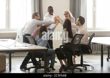 Happy diverse employees giving high five at business briefing Stock Photo