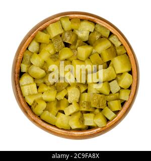 Pickled cucumber, diced, also known as pickle or gherkin, in wooden bowl. Small pickled cucumbers with bumpy skin, cut into cubes. Baby pickles. Stock Photo