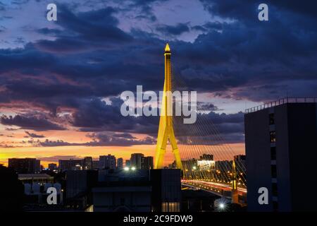 Illuminated Rama VIII. Bridge (Rama 8. Bridge), a suspension bridge spanning the Chao Phraya River in Bangkok, Thailand, during a colorful sunset Stock Photo