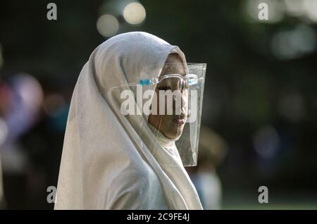 (200731) -- BANDUNG, July 31, 2020 (Xinhua) -- An Indonesian girl wearing a protective face shield attends Eid al-Adha prayers at Bandung Raya mosque in Bandung, West Java, Indonesia, July 31, 2020. (Photo by Septianjar/Xinhua) Stock Photo