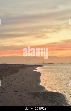 Sea coast during a colorful sunset on a slightly cloudy day. Summer. Stock Photo