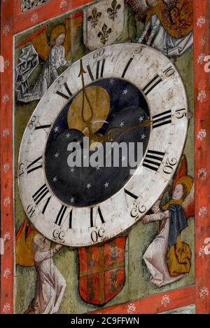 On the timber case of a 14th century striking clock, four angels, repainted on wood in the late 15th century, hold up a late 18th century dial.  The clock is said to be one of the oldest timepieces of its type in working condition in the world.  Chapel of St. Theresa of Lisieux in St. Peter’s Cathedral at Beauvais, Oise, Hauts-de-France, France. Stock Photo