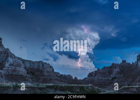 An active lightning storm over the mountains of Badlands National Park in South Dakota lights up the sky. Stock Photo