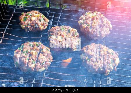 patties of ground meat on the cooking grate and food preparation. selective focus Stock Photo