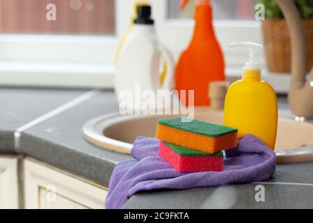 Household chemicals product bottles standing near the kitchen sink Stock Photo