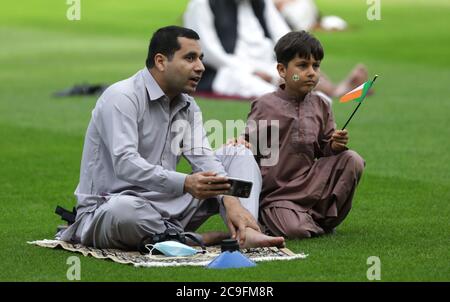 Kamil Ayub (right), aged 6, holds an Irish flag alongside his father (left) sitting on a prayer mat in Croke Park, Dublin, as mosques across Ireland are marking the occasion of Eid Al Adha, the festival of sacrifice - with the largest event taking place at GAA headquarters in Dublin. Stock Photo