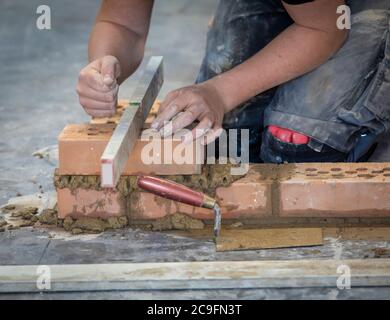 detail bricklayer with bubble level at work Stock Photo