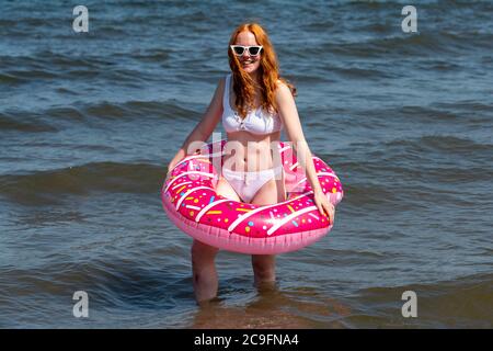 Edinburgh, Scotland, UK. 31 July, 2020. Temperature of 25C and sunshine brought huge crowds to Portobello Beach outside Edinburgh. Several large groups of teenagers were enjoying beach and alcoholic drinks were very popular. Iain Masterton/Alamy Live News Stock Photo