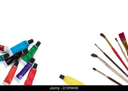 Tubes with multi-colored acrylic paints and paintbrushes isolated on white background. Creativity and hobby concept. Copy space Stock Photo