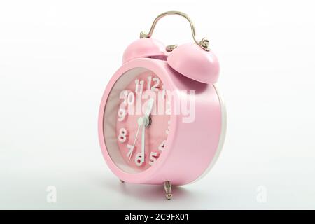 Sleep hygiene, wake up ring and old fashioned clocks concept with pink retro style alarm clock isolated on white background and clipping path cutout Stock Photo