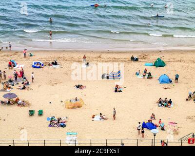 Poole, UK. 31st July, 2020. Bournemouth, UK. Friday 31 July 2020. Bournemouth beach is busy with people swimming in the sea as a weekend of hot weather gets going. Credit: Thomas Faull/Alamy Live News Stock Photo