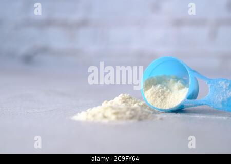 Close up of baby milk powder and spoon on tile background. Stock Photo