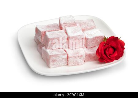 Turkish rose delight on a white dish and a fresh rose isolated on white background Stock Photo