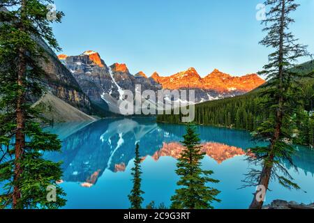 Golden sunrise over the Valley of the Ten Peaks with glacier-fed turquoise-colored Moraine Lake in the foreground near Lake Louise in the Canadian Roc Stock Photo