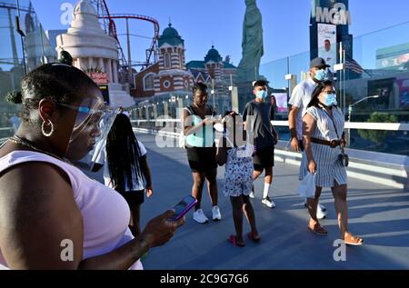 Las Vegas, Nevada, USA. 30th July, 2020. People wear face coverings as they stroll the Las Vegas Strip on July 30, 2020 in Las Vegas, Nevada. The state has a mandatory face covering policy in effect for anyone in any public space. Credit: David Becker/ZUMA Wire/Alamy Live News Stock Photo
