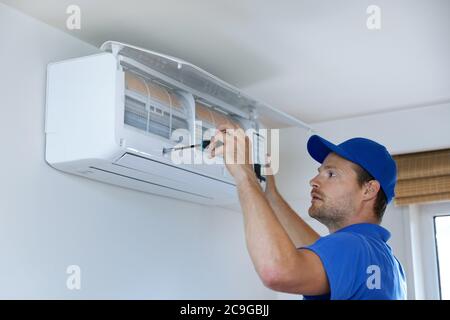 hvac services - technician installing air conditioner on the wall at home Stock Photo
