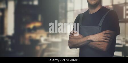 barista standing in coffee shop with arms crossed. copy space Stock Photo