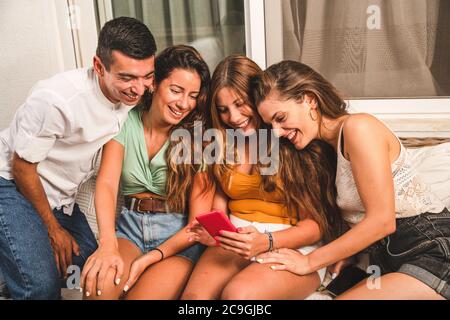 Group of Happy Friends Having Fun Together Using a Smart Phone. People addicted by Smart Phone on the Social Media Stock Photo