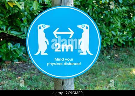 Amusing sign about coronavirus covid-19 social distancing safety rules at a zoo after lockdown eased, UK, July 2020 Stock Photo