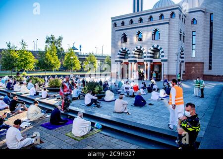 Rotterdam, Netherlands. 31st July, 2020. A policeman stands on guard outside Essalam mosque while wearing a face mask as a preventive measure during Eid al-Adha amid Coronavirus (COVID-19) crisis.Eid al-Adha, also called Eid Qurban or Bakra-Eid, is the second of two Islamic holidays celebrated worldwide each year, and considered the holier of the two. It honours the willingness of Ibrahim to sacrifice his son Ismael as an act of obedience to God's command. Credit: SOPA Images Limited/Alamy Live News Stock Photo