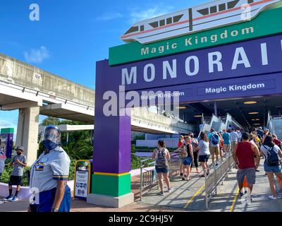 Orlando,FL/USA-7/25/20: People wearing face masks and social distancing while waiting in line to get on the monorail at  Walt Disney World Resorts in Stock Photo