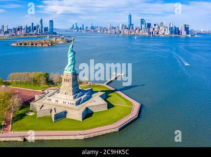 Aerial view of the Statue of Liberty from New York Harbor overlooking Ellis Island, Jersey City and the Lower Manhattan skyline Stock Photo