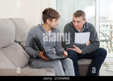 Father helping son to do homework Stock Photo