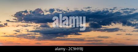 Dramatic panoramic skyscape with dark stormy clouds during sunrise Stock Photo