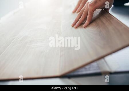 Close-up of the work of a master floating flooring installation - installing laminate on the floor - male hands during work Stock Photo