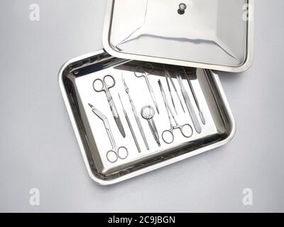 Surgical equipment in a tray against a grey background. Stock Photo