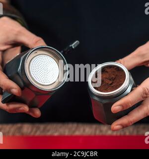 Making Coffee with Stovetop Moka Pot. Female Barista putting ground coffee in Stovetop Moka Pot. Stock Photo