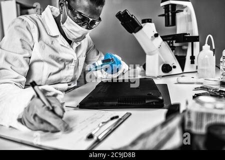 Forensic Science Data. Forensic analyst examining laptop computer. Stock Photo