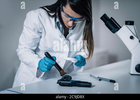 Forensic Science in Lab. Forensic Scientist examining gun for evidence. Stock Photo
